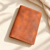 Tan stitched Grecorium leather passport cover on ivory linen